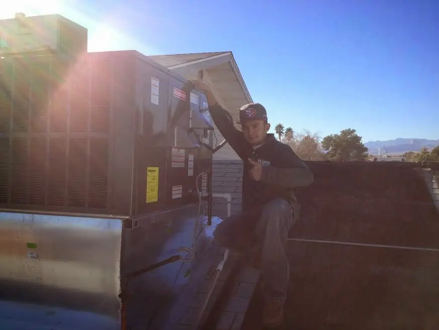 HVAC technician performing Boiler Repair on a rooftop unit in Montevideo